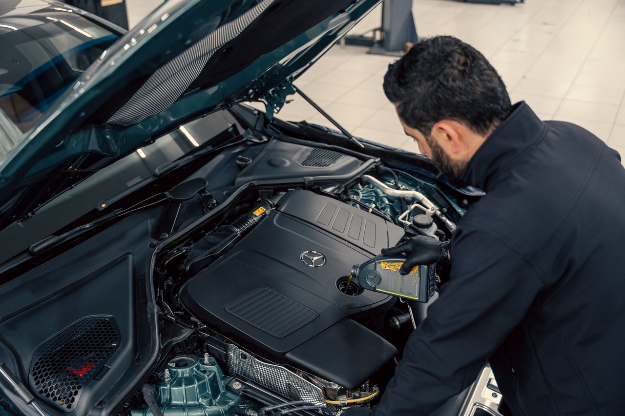 Crafting Captivating Headlines: Your awesome post title goes here Mechanic inspecting and filling engine oil in a car at an indoor service center.